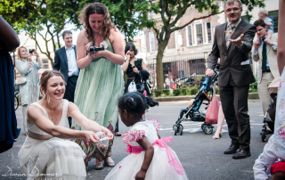 Bride collects coins tradition in front of the Stoke Newington Town Hall | London Wedding Photography